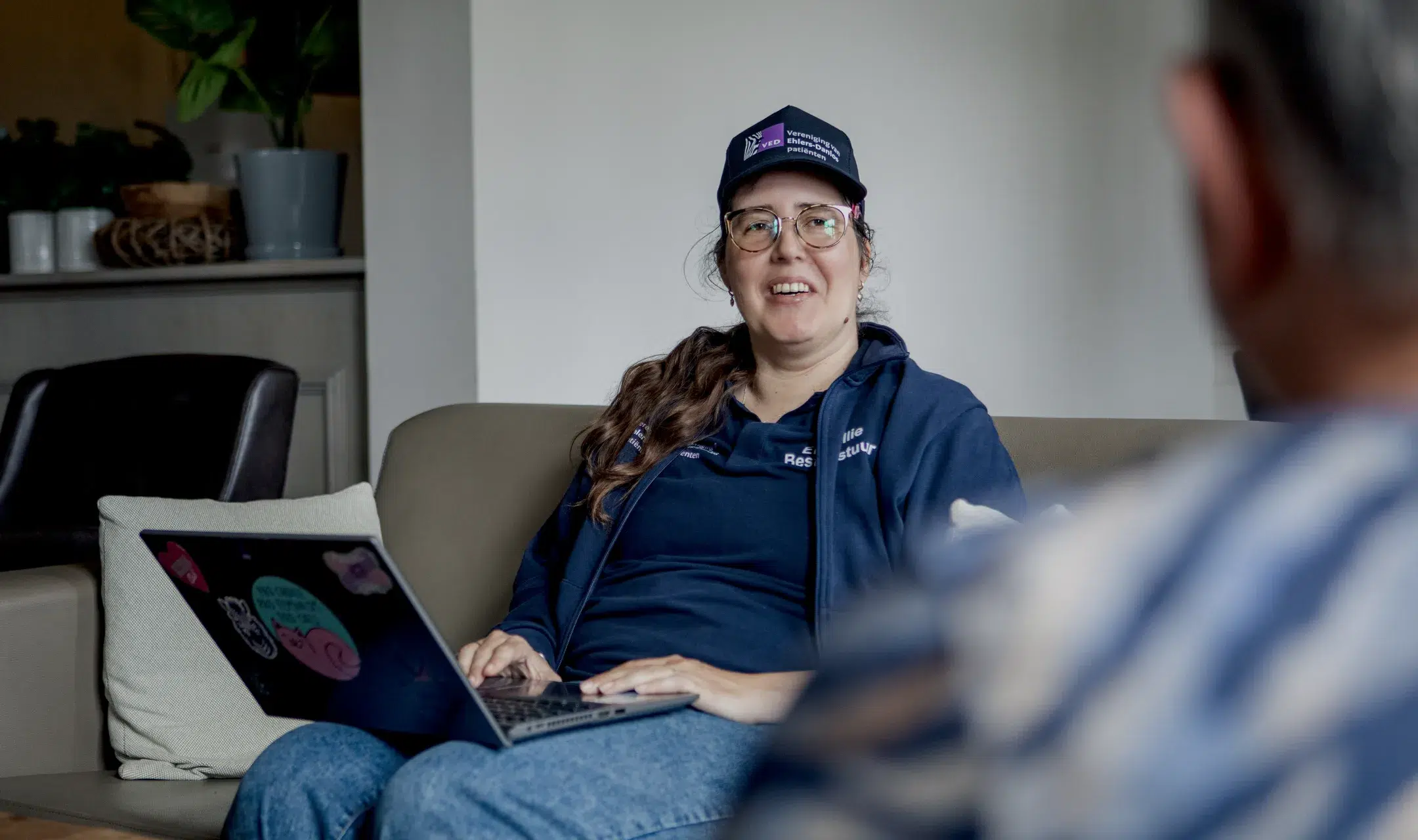 Lid van de Vereniging van Ehlers-Danlos Patiënten met een laptop op de bank